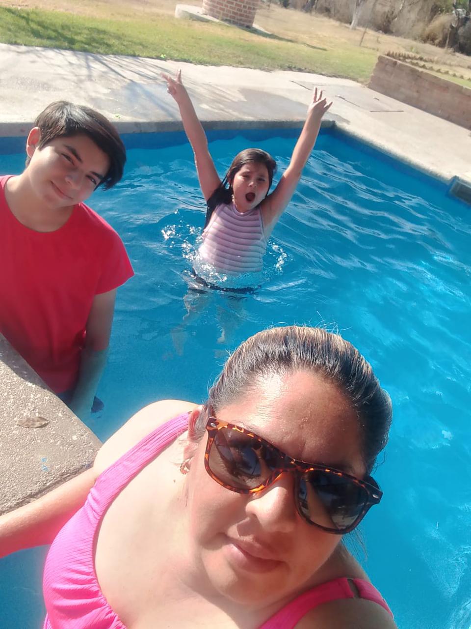 Niños saltando y jugando en la alberca de día